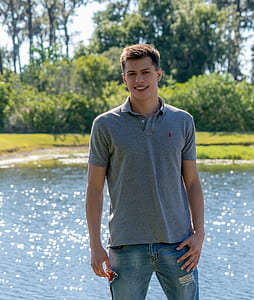 man standing in front of calm body of water thumbnail
