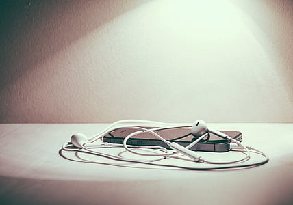black iPhone 5 with EarPods on table thumbnail