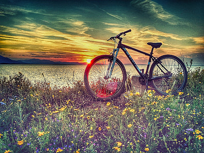 black hardtail mountain bike beside the body of water during sunsset thumbnail