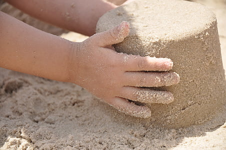 child holding pile of sand thumbnail