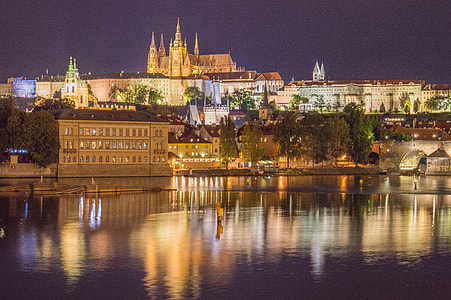 lighted concrete buildings near river at nighttime thumbnail