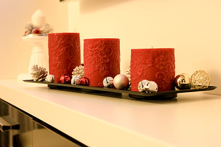 three red nesting pillar candles on white wooden table thumbnail