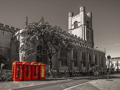 selective color photography of four red telephone booth besides building thumbnail