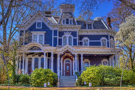 blue and beige 3-storey house with green bushes under clear sky during daytime thumbnail