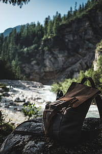 brown backpack on grey rock selective focus photography thumbnail