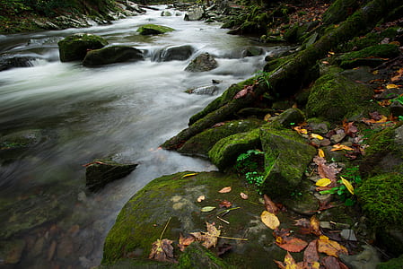 flowing river surrounded by rocks thumbnail
