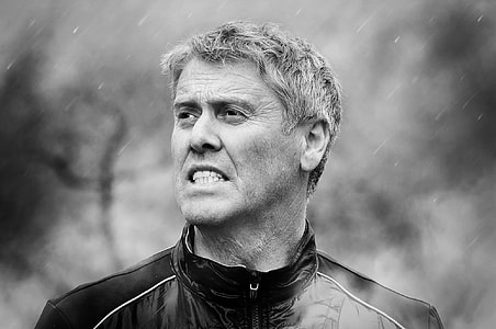 grayscale photo of man wearing zipped-up up turtle-neck jacket thumbnail