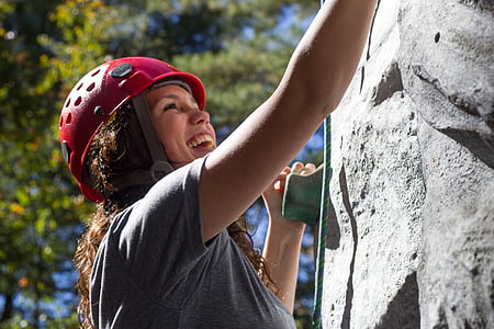 woman in gray shirt climbing on gray wall thumbnail