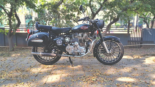black standard motorcycle parked beside green tree thumbnail