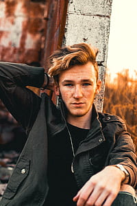 man sitting holding at wall during golden hour thumbnail