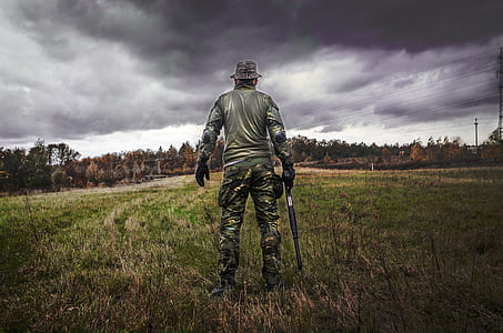 Man in Camouflage Suit Holding Shotgun thumbnail