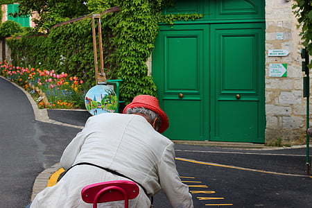 man sitting in front of green wooden gate during daytime thumbnail