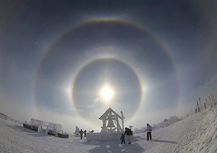group of people beside bell coated snow thumbnail