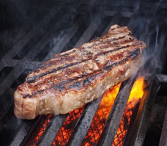 grilled beef on top of black steel charcoal grill thumbnail