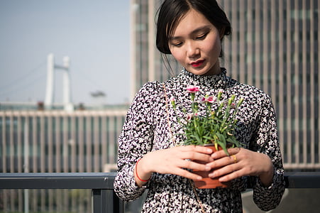 woman holding green plant thumbnail
