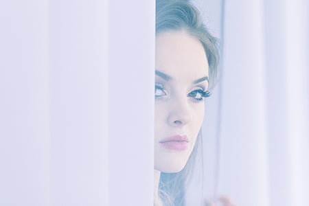 woman standing beside pink curtains thumbnail