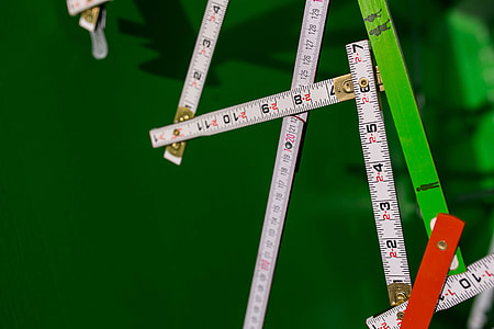 Extandable wooden ruler on a green background thumbnail