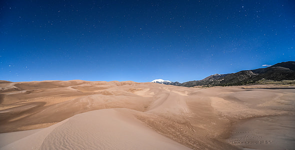 desert under blue sky near black hill s thumbnail