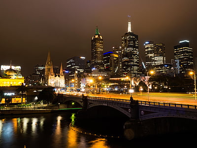 bridge near high rise buildings during nighttime thumbnail