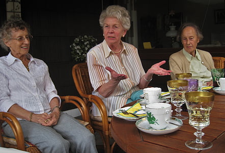 three dressed woman sitting near table thumbnail
