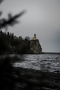 white and brown lighthouse near cliff thumbnail