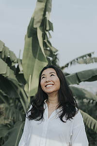 smiling woman standing near banana tree thumbnail