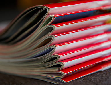 selective focus photography piled red magazine books thumbnail