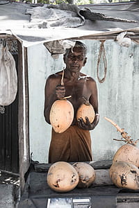 man holding two coconuts thumbnail