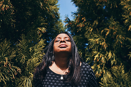 woman closing eyes near trees thumbnail
