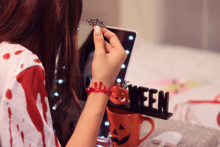 woman in front of mirror holding halloween decor thumbnail