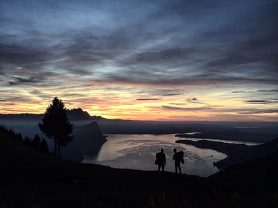silhouette of two person standing on cliff thumbnail