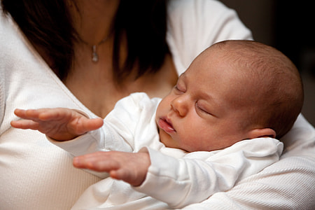 person holding baby, wearing white long-sleeved shirt thumbnail
