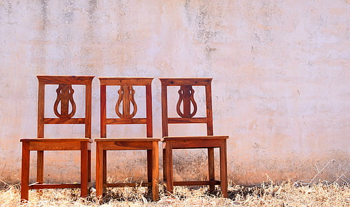 three brown wooden chairs beside pink wall thumbnail