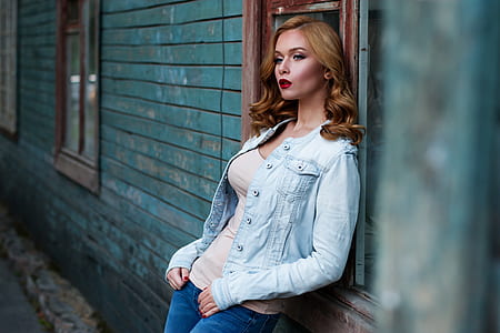 woman standing beside wall during daytime thumbnail