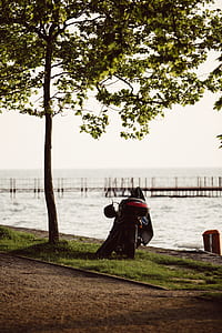 black motorcycle parked near body of water thumbnail