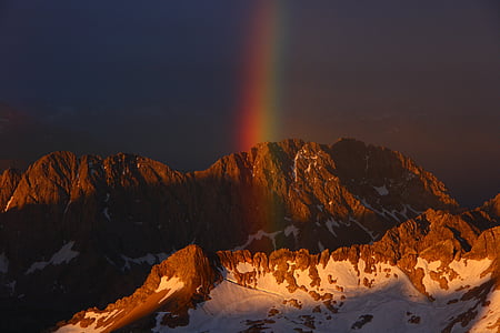 landscape photography of rainbow near rock formation thumbnail