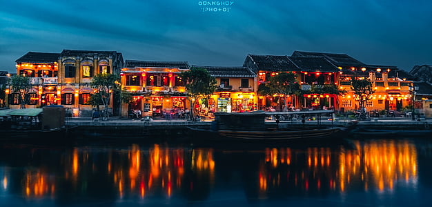 lighted building near body of water at night thumbnail