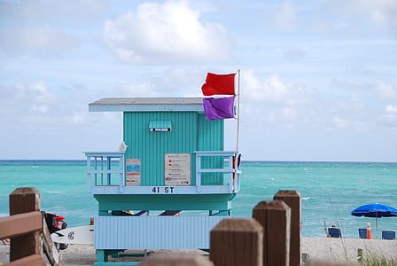 teal and white beach stand near water thumbnail