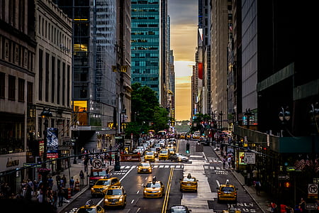 aerial photography of vehicles on road between buildings during golden hour thumbnail
