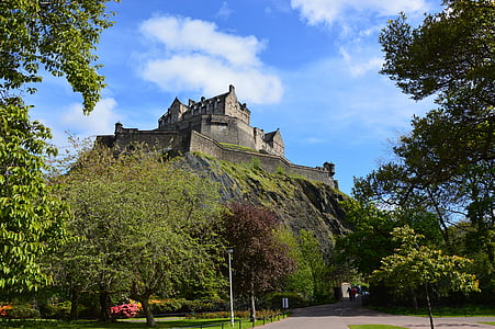grey castle on hilltop under cloudy sky thumbnail