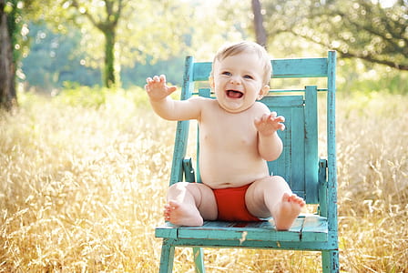 baby sitting on blue wooden chair thumbnail