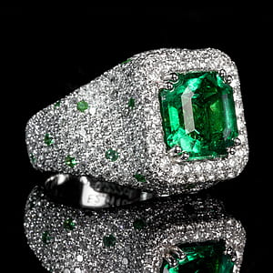 green and clear jeweled silver-colored ring on glass surface thumbnail