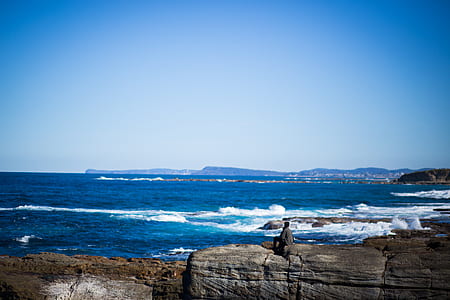 brown rock formation near body of water at daytime thumbnail