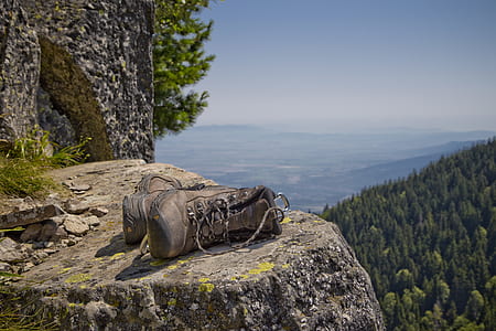 pair of brown boots on gray rock during daytime thumbnail