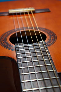 shallow focus photography of brown and black acoustic guitar thumbnail