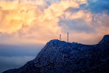 two communication towers on mountain top during sunset thumbnail