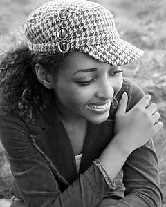 smiling woman wearing denim notched lapel jacket and houndstooth cap thumbnail
