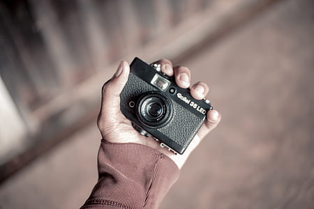 person holding vintage black camera thumbnail