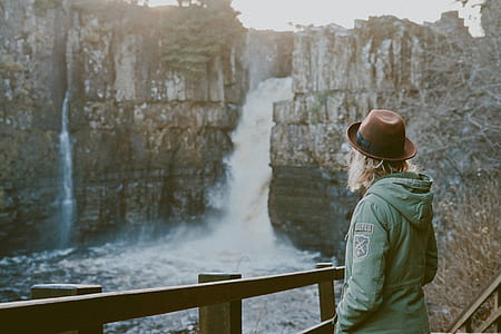 woman standing near waterfalls during daytime thumbnail
