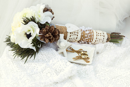 white flowers with pine cones bouquet and pair of gold-colored earrings thumbnail